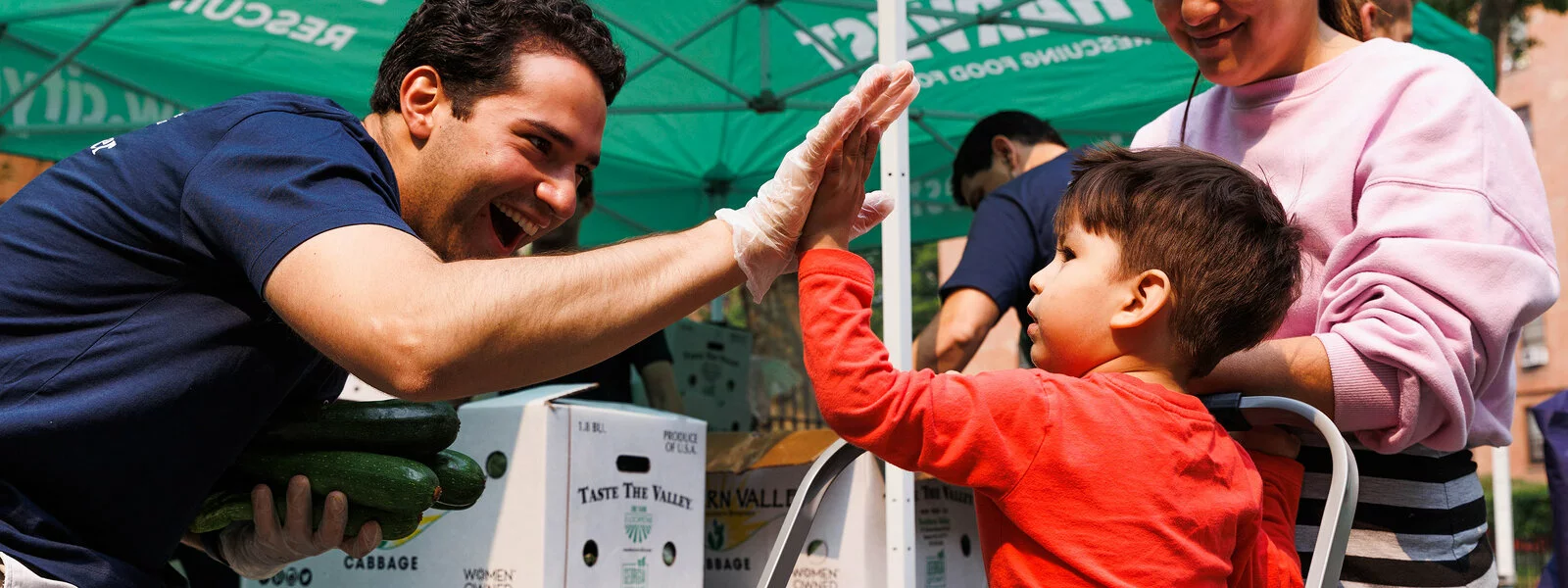 A young boy high fives a man