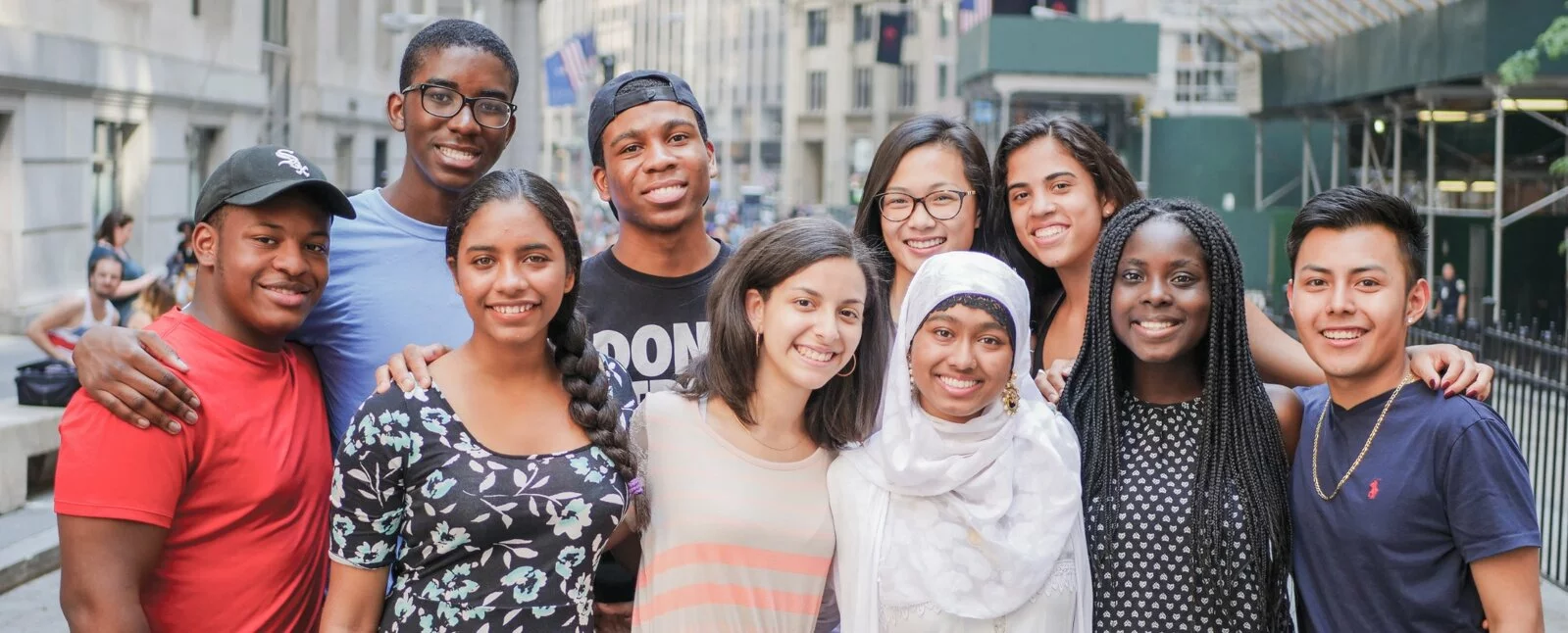 Ten students stand together with the city in the background.