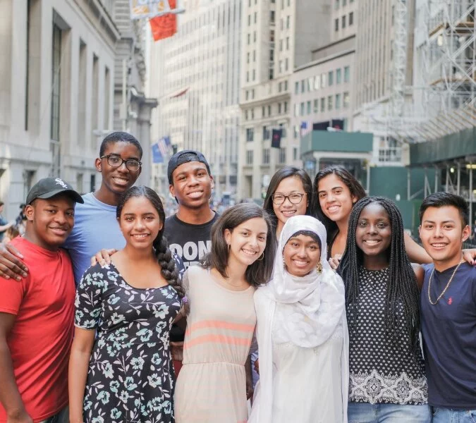 Ten students stand together with the city in the background.