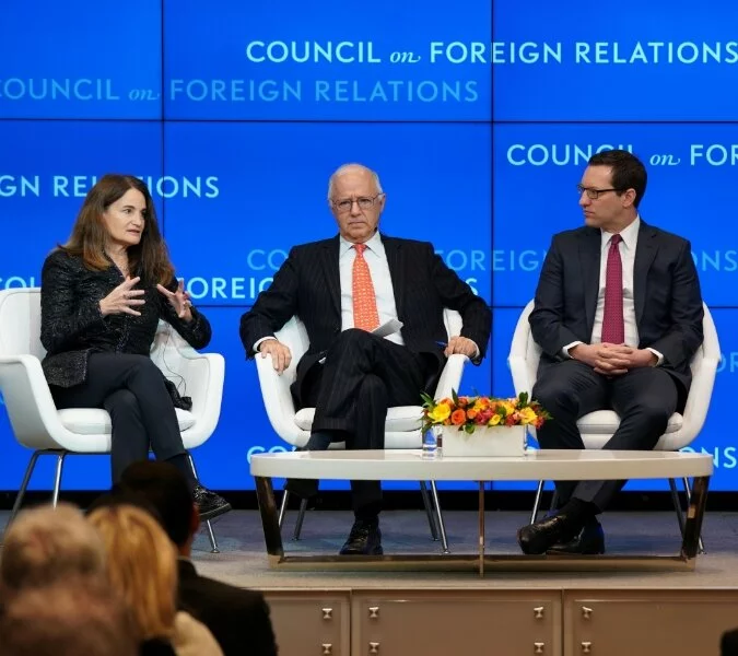 Three people on stage in front of a Council on Foreign Relations background