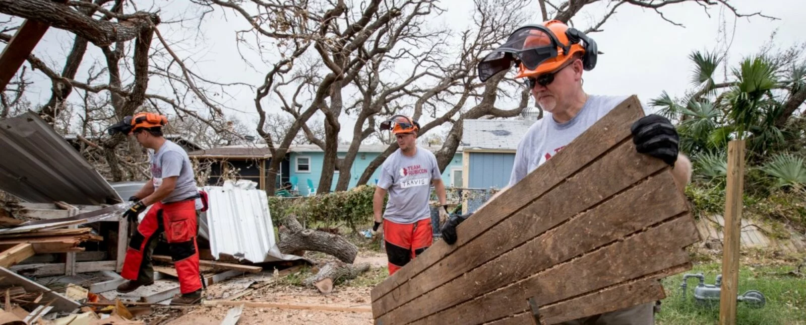 Three men work to clean up debris