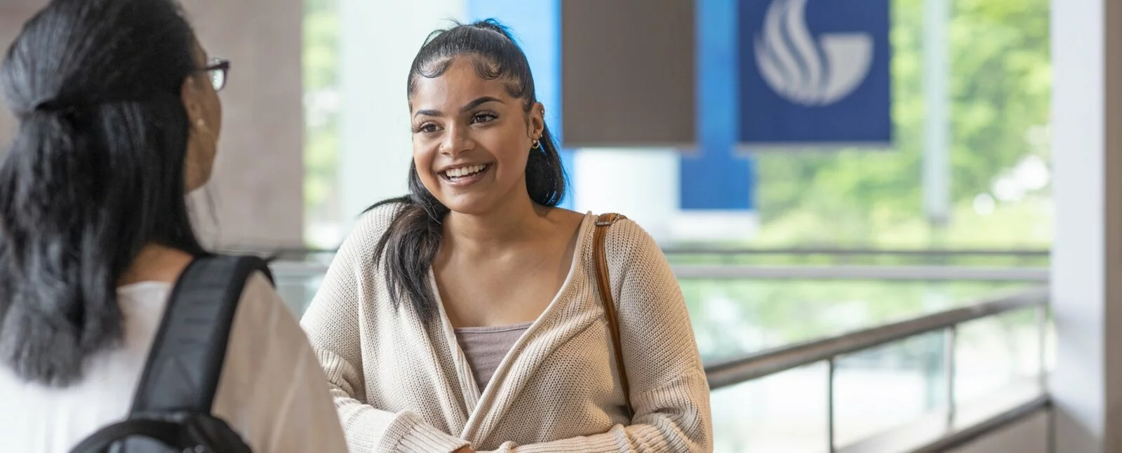 Two women talking, one smiling, at Georgia State