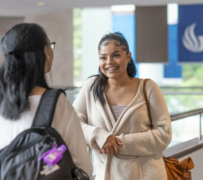 Two women talking, one smiling, at Georgia State