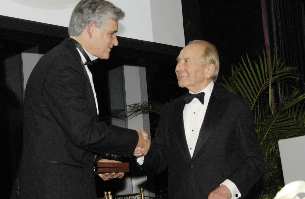 Mr. Greenberg shakes hands with Dr. Bruce Stillman. Both men are wearing tuxedos.