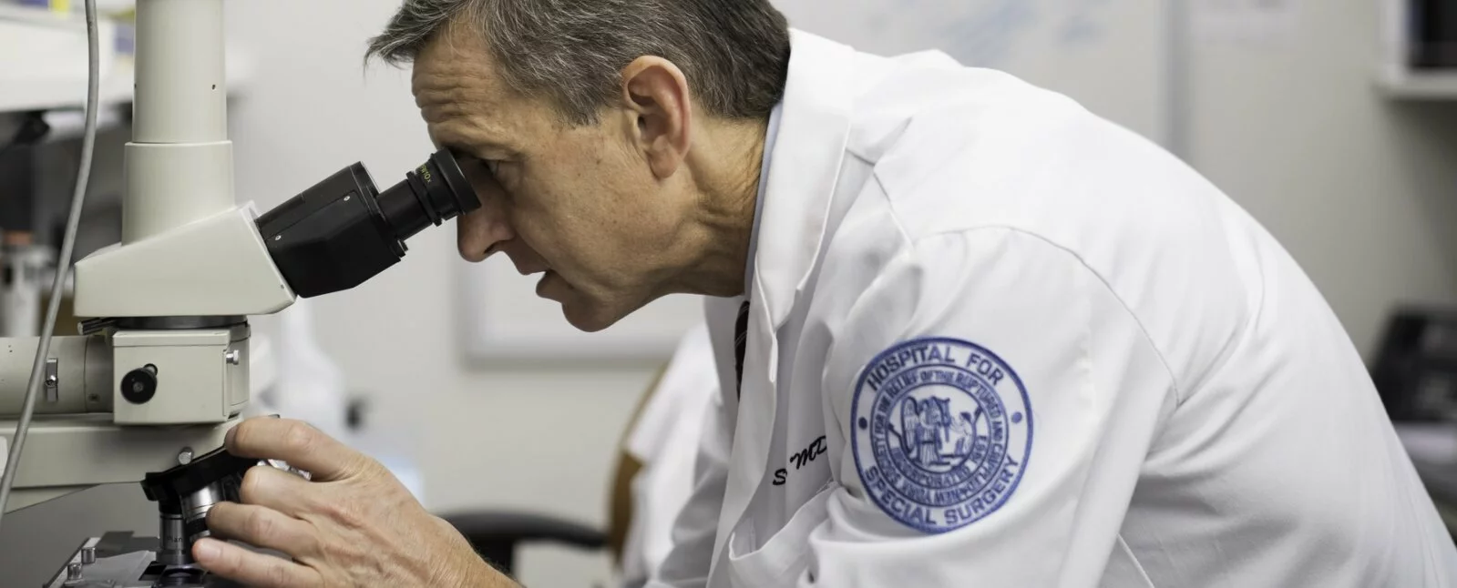 A surgeon reviews a slide in the lab