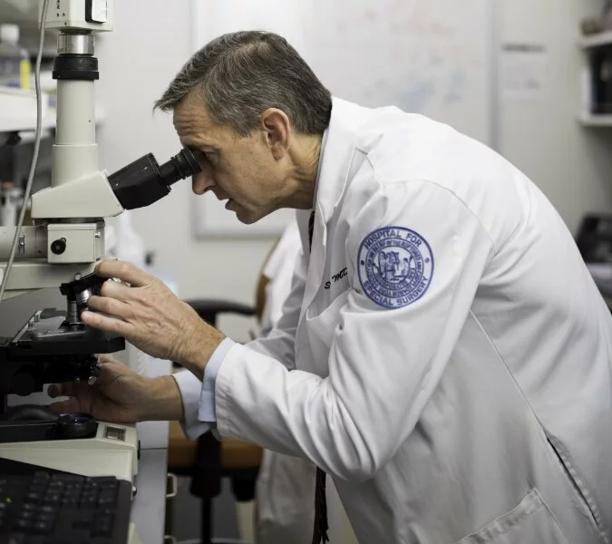 A surgeon reviews a slide in the lab