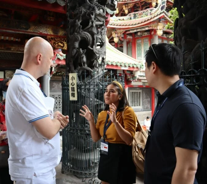 Three students stand talking outside