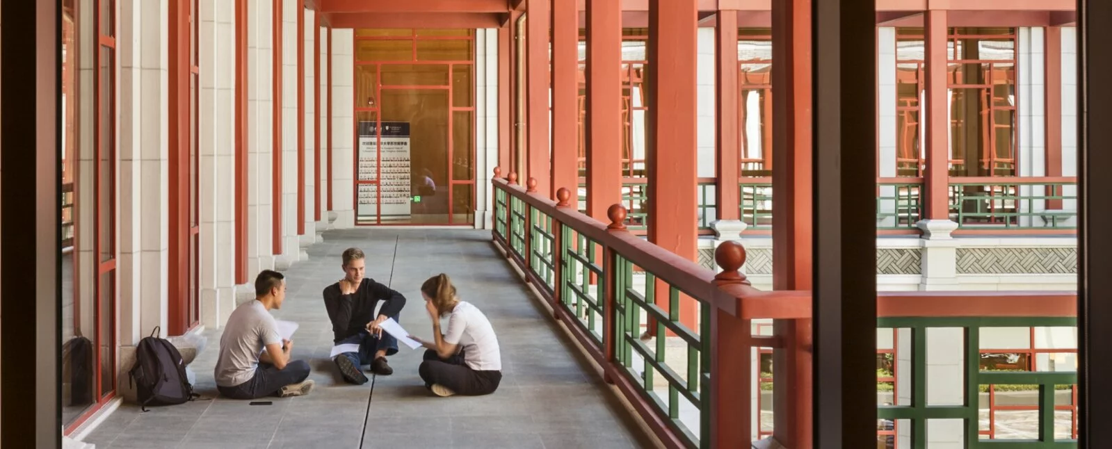 Three students sit outside talking