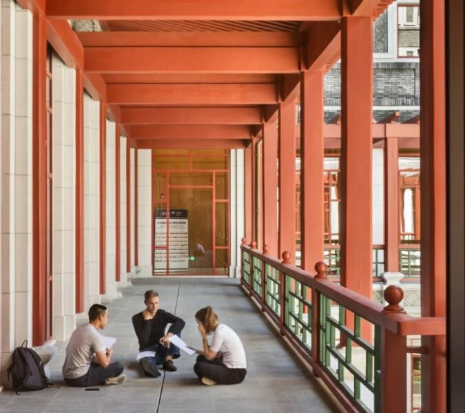 Three students sit outside talking